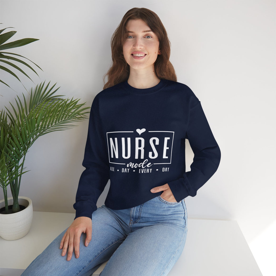 Woman wearing a Navy Blue sweatshirt with 'Nurse Mode All Day Every Day' printed in white text, a stethoscope around her neck, and hands on her waistband. Stylish design perfect for Nurses Week Custom Shirt Suggestions.