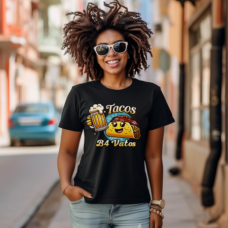 Black t-shirt featuring a fun 'Tacos B4 Vatos' design with a smiling taco character wearing a bandana and holding a beer mug. Perfect for taco lovers who prioritize food and fun with a playful style.