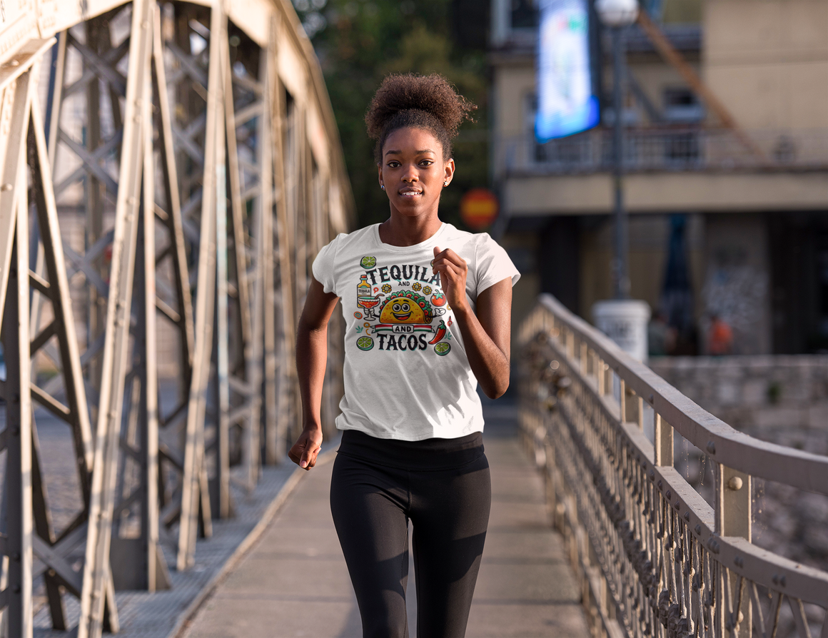 White T-shirt featuring a festive 'Tequila and Tacos' design with a smiling taco character, tequila bottle, margarita glass, lime slices, and chili peppers. Perfect for celebrating fiestas and taco nights with a fun and lively style.