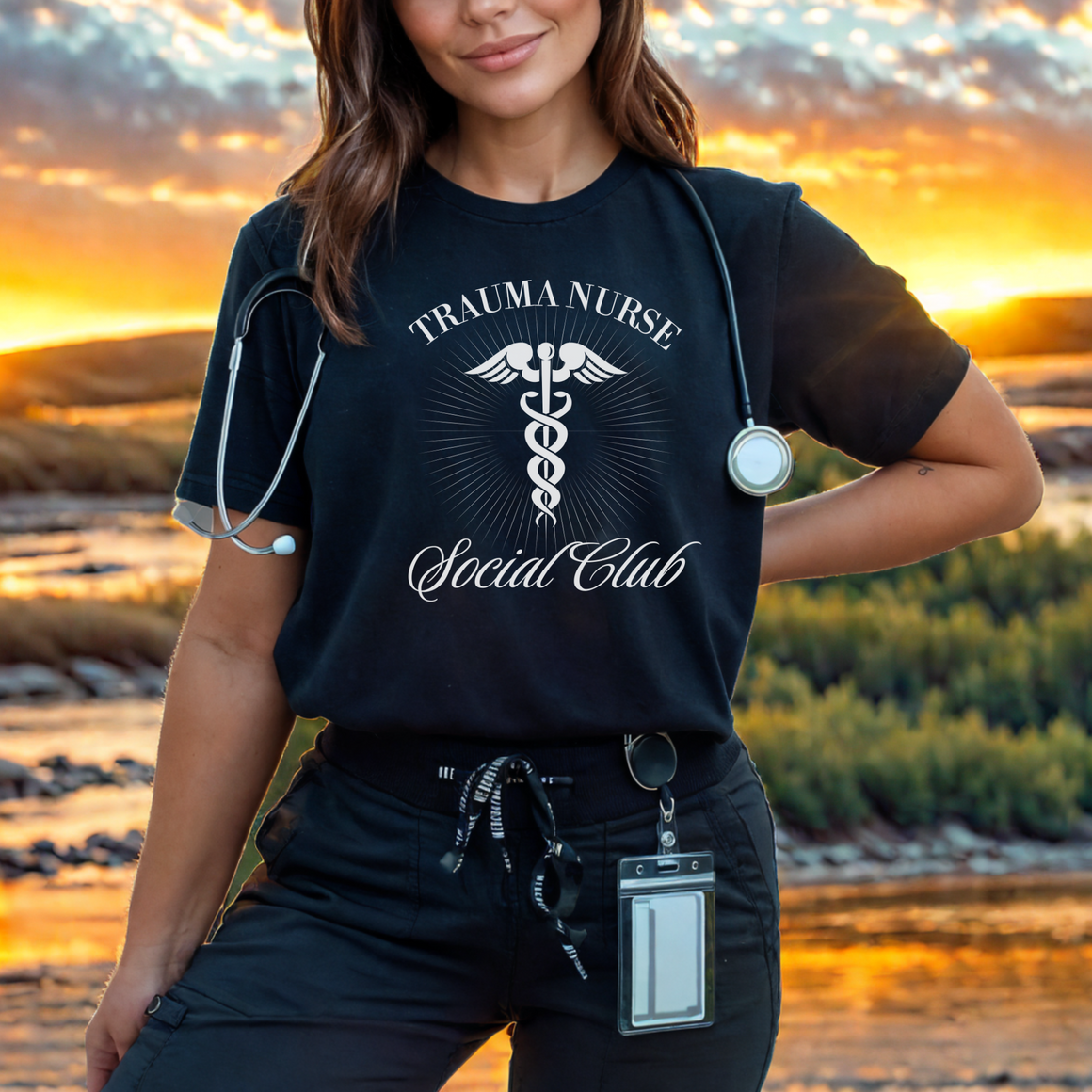 A nurse standing wearing a shirt that says Trauma Nurse Social Club and has a grapgic of a nurses caduceus