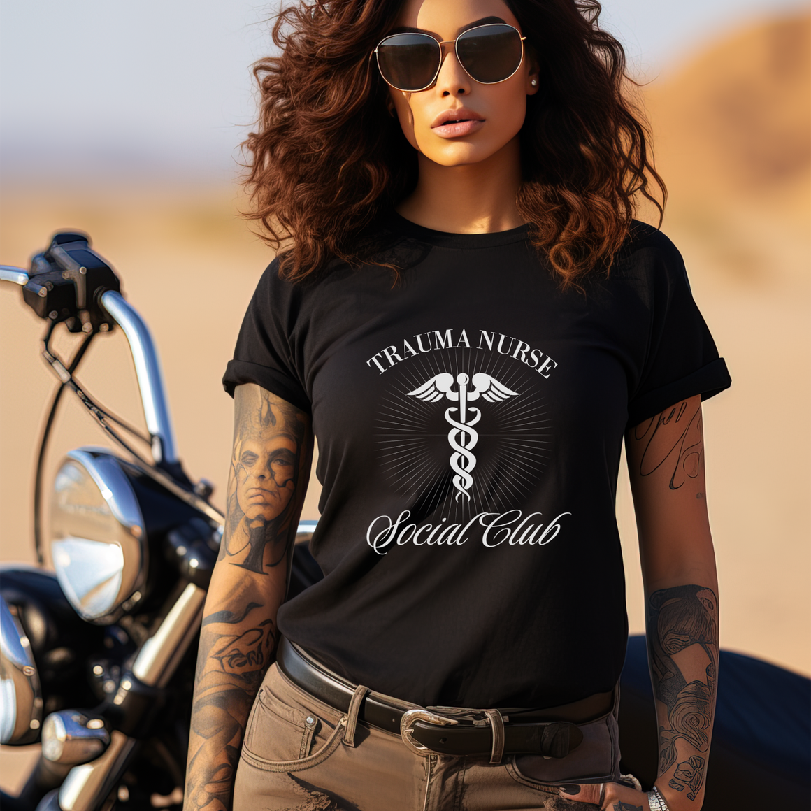 A nurse standing wearing a shirt that says Trauma Nurse Social Club and has a grapgic of a nurses caduceus