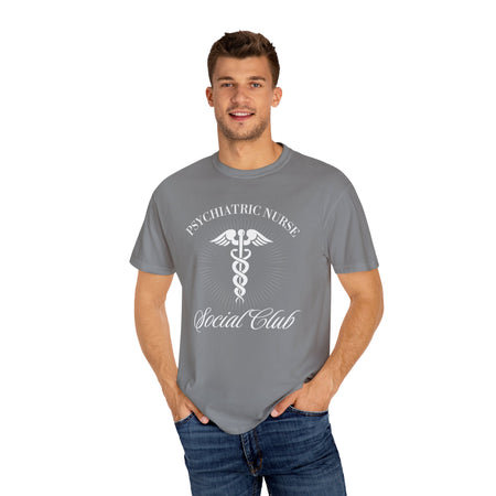 A nurse standing wearing a shirt that says Psychiatric Nurse Social Club and has a grapgic of a nurses caduceus