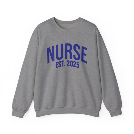 A  sport grey sweatshirt with bold blue text reading "NURSE EST. 2025." He stands confidently against a plain white background, smiling slightly. The sweatshirt design highlights the keyphrase "Nurse Est. 2025," making it a stylish and comfortable option for nursing students, graduates, or future nurses.
