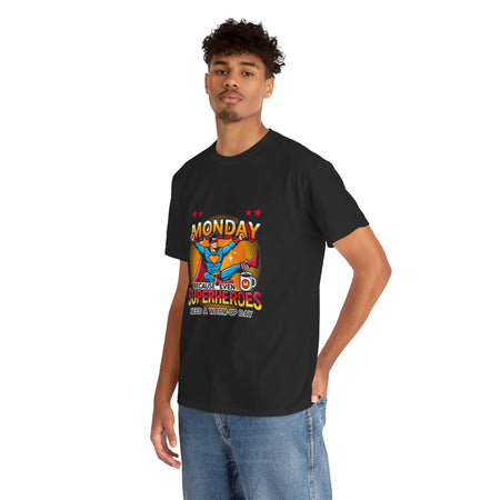 a Man wearing a black t-shirt with a humorous design featuring a superhero and the text 'Monday - Because Even Superheroes Need a Warm-Up Day.' A playful option in funny t-shirts for adults.