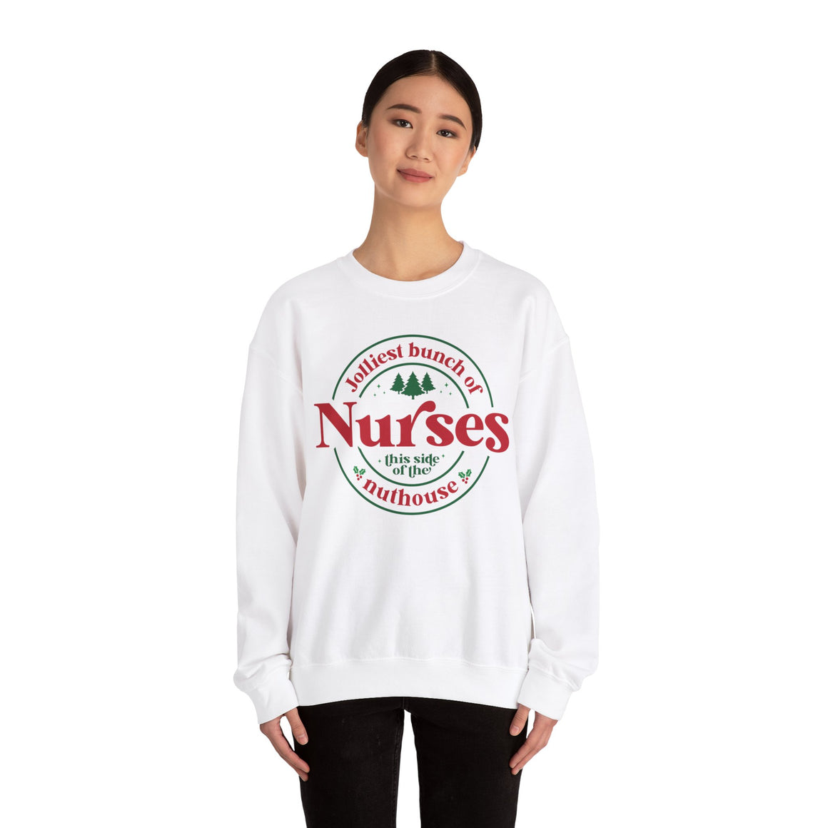 White Christmas sweatshirt with the humorous phrase 'Jolliest bunch of Nurses this side of the nuthouse,' surrounded by festive elements like trees and holly. A perfect holiday-themed gift for nurses with a sense of humor, celebrating Christmas in a fun and lighthearted style.