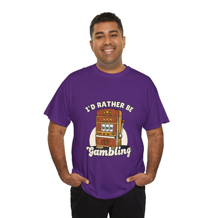 Person wearing a purple t-shirt with the text "I'd Rather Be Gambling" and an illustration of a slot machine. This funny casino game shirt is perfect for anyone who loves gambling humor and casino-inspired designs