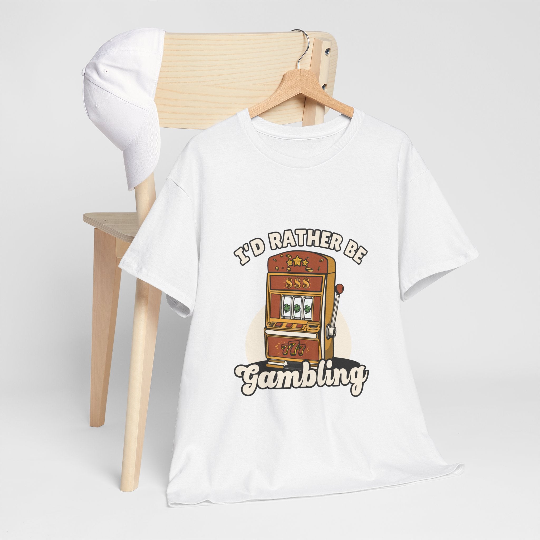 a white t-shirt with the text "I'd Rather Be Gambling" and an illustration of a slot machine. This funny casino game shirt is perfect for anyone who loves gambling humor and casino-inspired designs