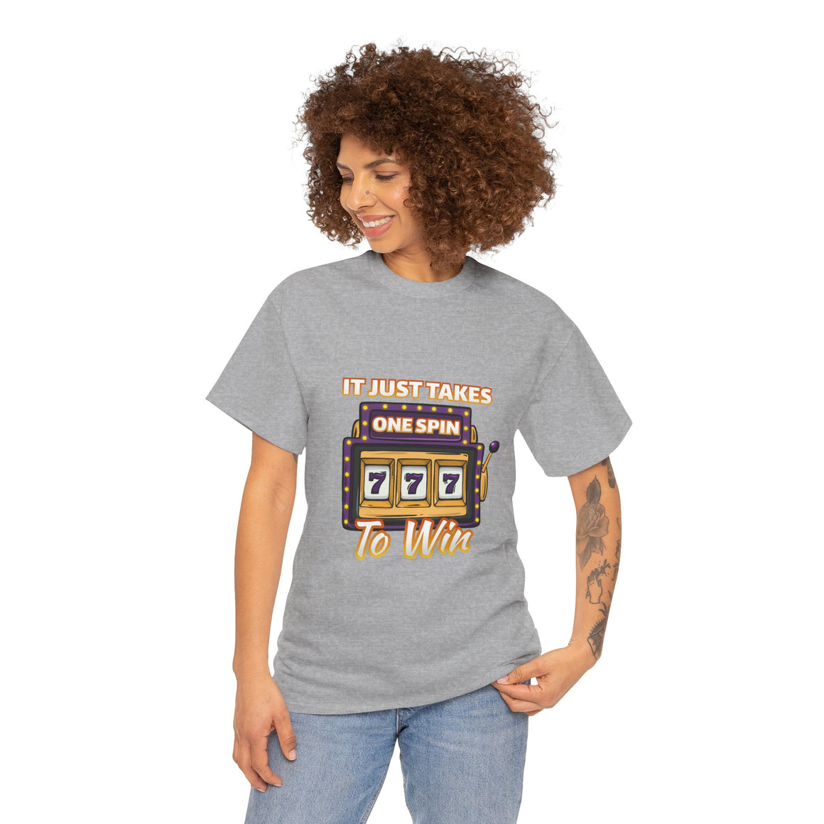Person wearing a grey t-shirt with the text "It Just Takes One Spin To Win" and a slot machine showing triple sevens. This shirt is one of the humorous casino-inspired shirts, perfect for anyone who enjoys a touch of gambling humor and the excitement of casino games.