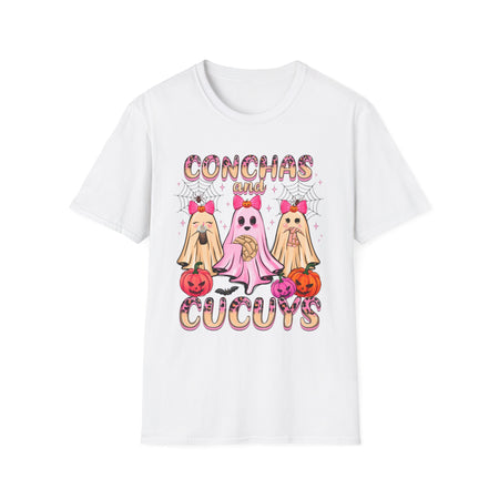 A white t-shirt featuring the "Conchas and Cucuy's" design, part of our Latino-inspired Halloween apparel. The shirt displays three cute ghost figures holding conchas and decorated with pink bows, spider webs, and festive pumpkin accents, combining Halloween spirit with Día de los Muertos charm. This unisex, soft-style shirt offers a unique blend of spooky and sweet for the Halloween season.