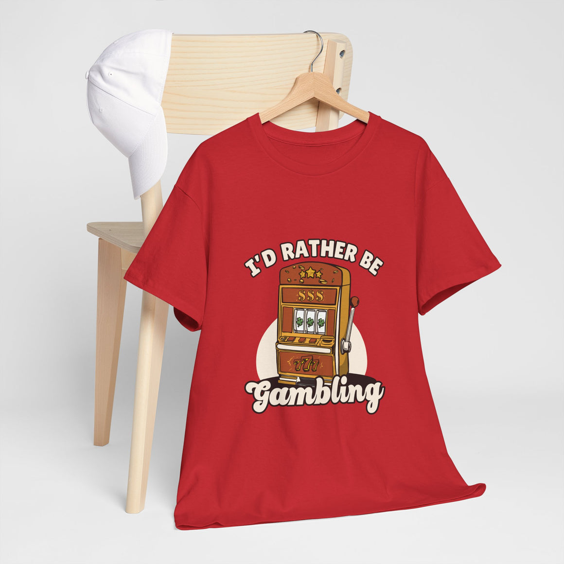 a red t-shirt with the text "I'd Rather Be Gambling" and an illustration of a slot machine. This funny casino game shirt is perfect for anyone who loves gambling humor and casino-inspired designs