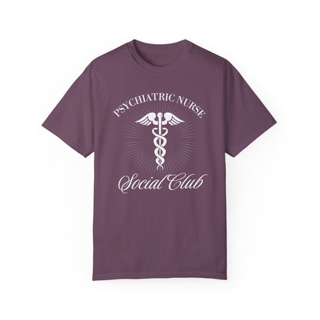 A nurse standing wearing a shirt that says Psychiatric Nurse Social Club and has a grapgic of a nurses caduceus