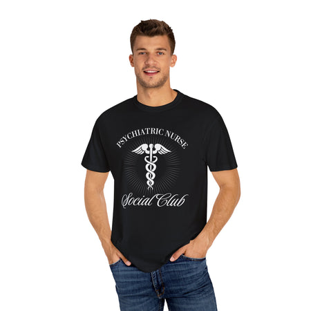 A nurse standing wearing a shirt that says Psychiatric Nurse Social Club and has a grapgic of a nurses caduceus