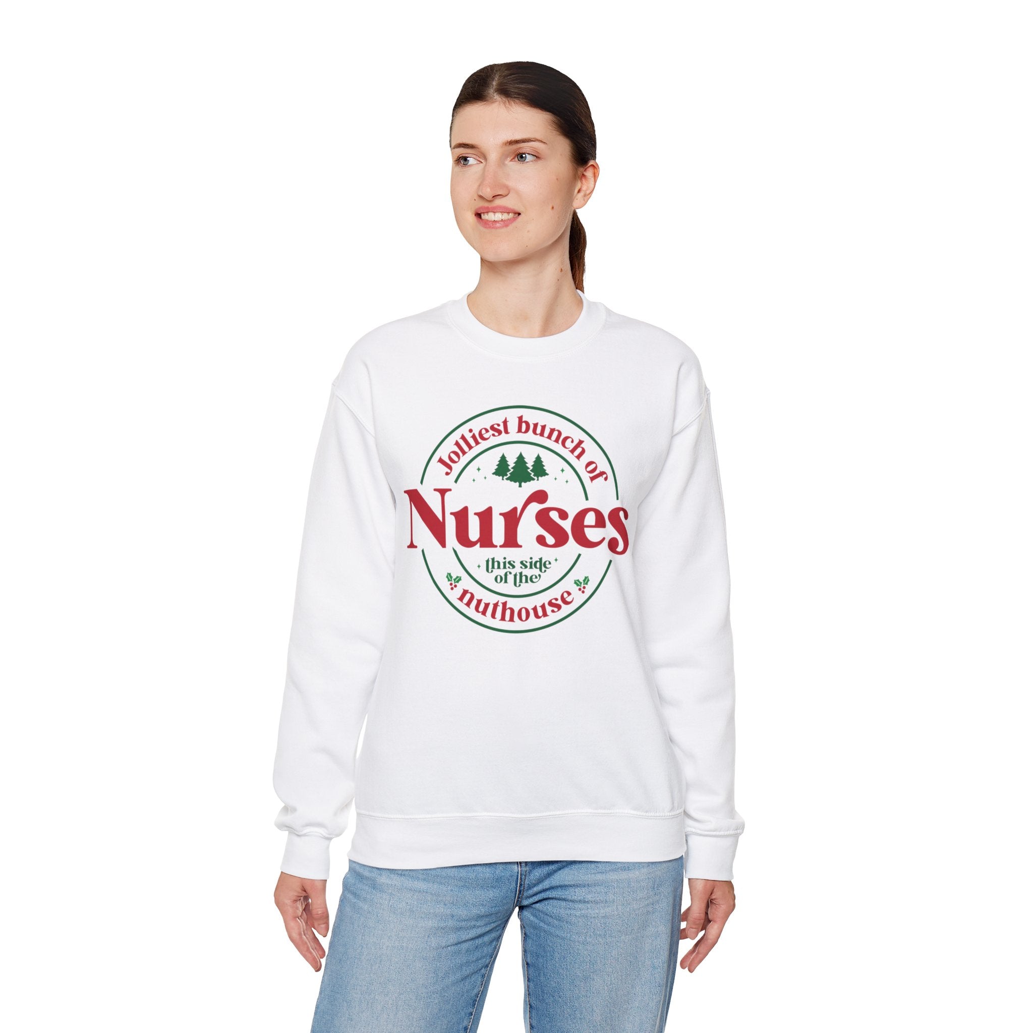 White Christmas sweatshirt with the humorous phrase 'Jolliest bunch of Nurses this side of the nuthouse,' surrounded by festive elements like trees and holly. A perfect holiday-themed gift for nurses with a sense of humor, celebrating Christmas in a fun and lighthearted style.