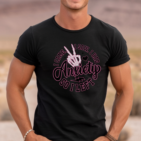 A woman wearing a gray T-shirt with the playful phrase "I Came. I Saw. I Had Anxiety So I Left," featuring a skeleton hand making a peace sign. This Funny Anxiety T-shirt humorously captures the sentiment with bold, creative lettering and symbols.