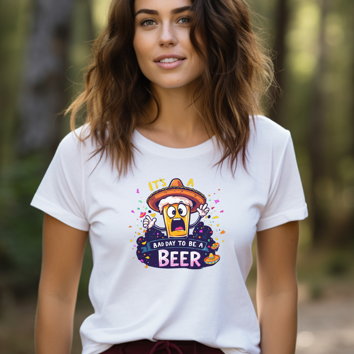 Woman wearing a white Fiesta San Antonio T-shirt featuring a cartoon beer character in a sombrero, surrounded by colorful confetti. The text reads 'It's a bad day to be a beer.