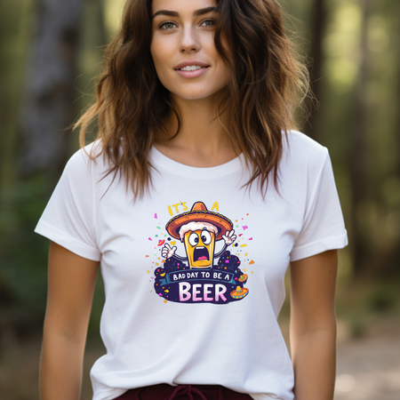 Woman wearing a white Fiesta San Antonio T-shirt featuring a cartoon beer character in a sombrero, surrounded by colorful confetti. The text reads 'It's a bad day to be a beer.