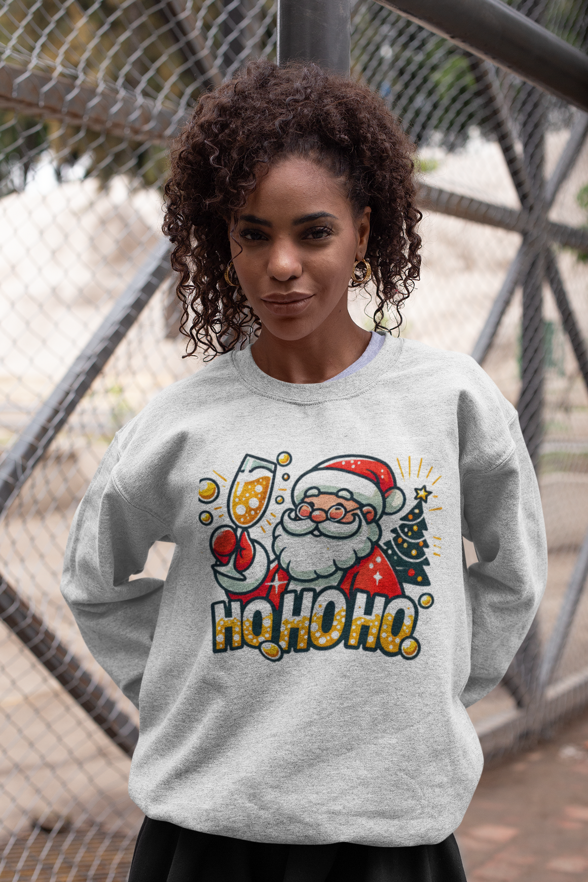 White Christmas sweatshirt featuring a cheerful Santa holding a champagne glass, next to a decorated Christmas tree and the festive text 'Ho Ho Ho.' A fun holiday sweatshirt perfect for adding Christmas cheer to any celebration.