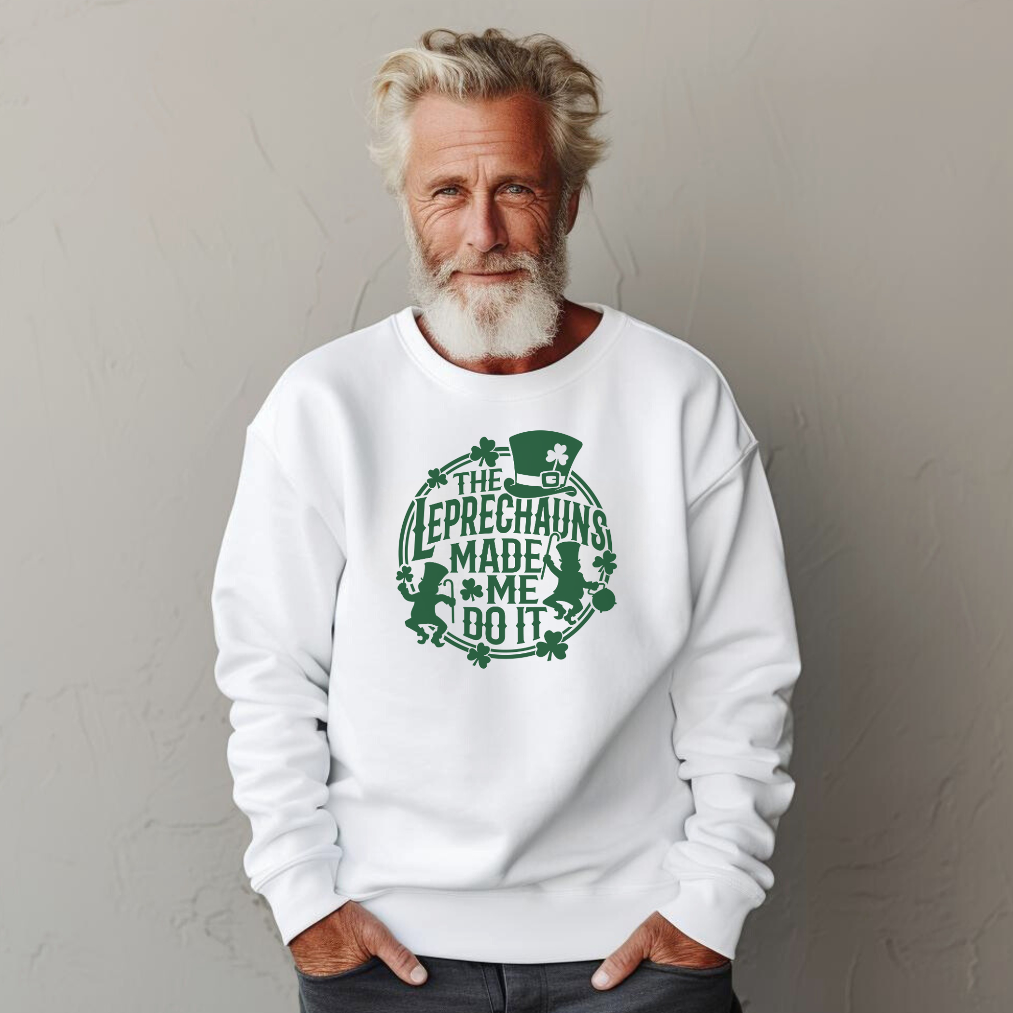 A man with gray hair and a beard wearing a white St. Patrick's Day sweatshirt with a green design featuring leprechauns and the text 'THE LEPRECHAUNS MADE ME DO IT.
