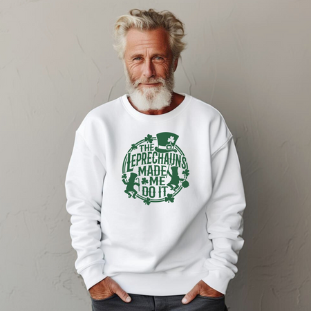 A man with gray hair and a beard wearing a white St. Patrick's Day sweatshirt with a green design featuring leprechauns and the text 'THE LEPRECHAUNS MADE ME DO IT.