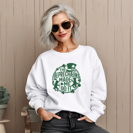 A woman with gray hair wearing sunglasses and a white St. Patrick's Day sweatshirt with a green design featuring leprechauns and the text 'THE LEPRECHAUNS MADE ME DO IT.'