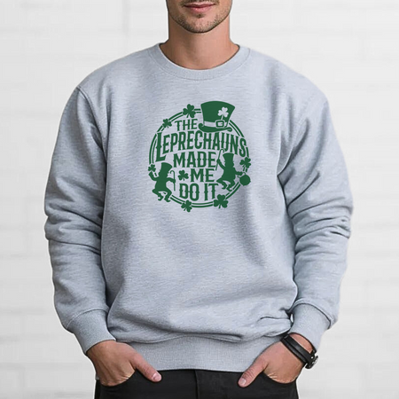 A man wearing a light gray St. Patrick's Day sweatshirt with a green design featuring leprechauns and the text 'THE LEPRECHAUNS MADE ME DO IT.'