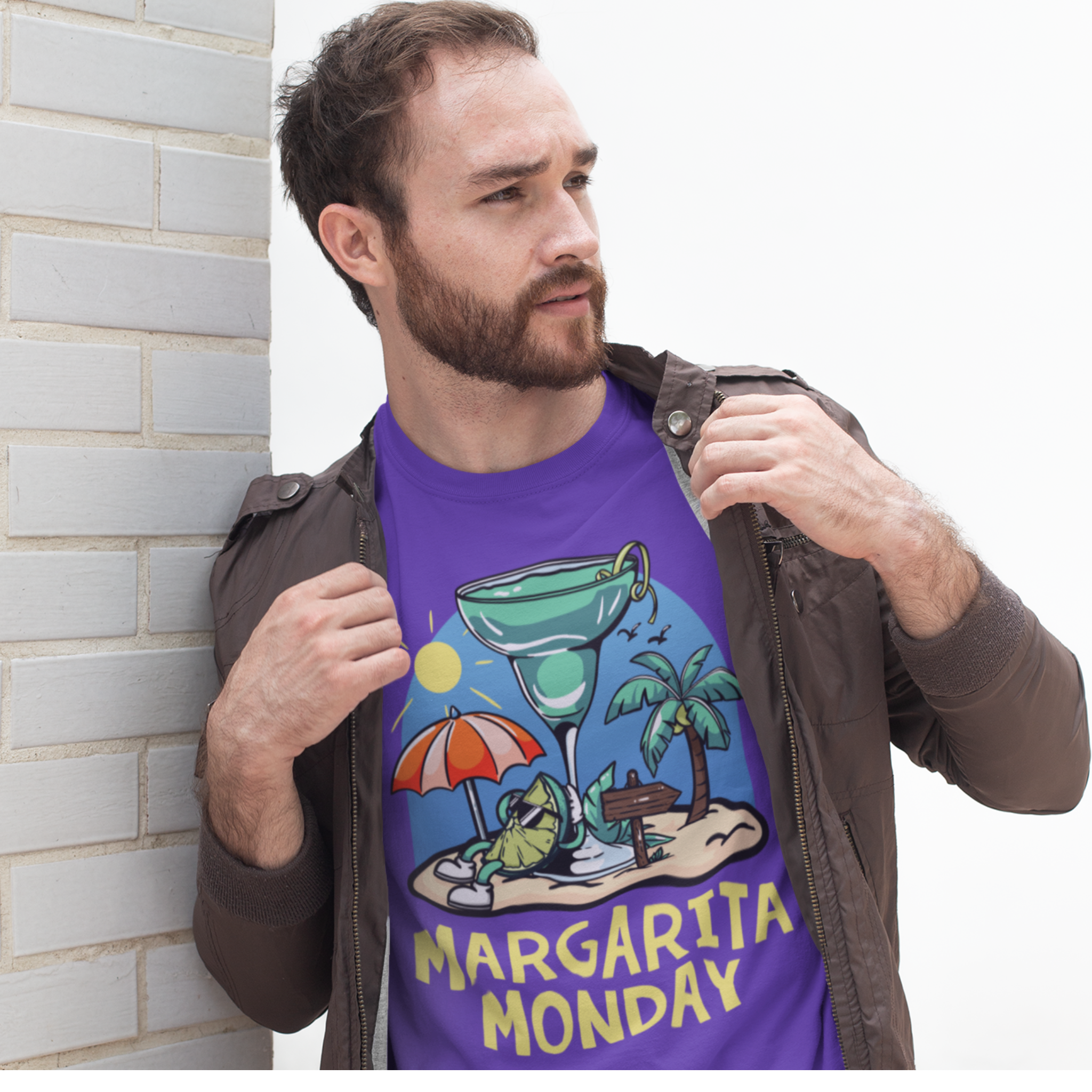 A man wearing a purple t-shirt with a fun "Margarita Monday" design, showcasing tropical vibes with a large margarita glass, palm trees, and a beach scene. 