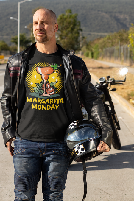 Man wearing a black T-shirt with a "Margarita Monday" design, featuring a vibrant margarita glass graphic, under a leather jacket while holding a motorcycle helmet. This is one of the trendy Margarita Monday T-shirt styles, perfect for adding a fun and bold twist to his rugged, biker look, ideal for casual outings or Margarita Monday celebrations.