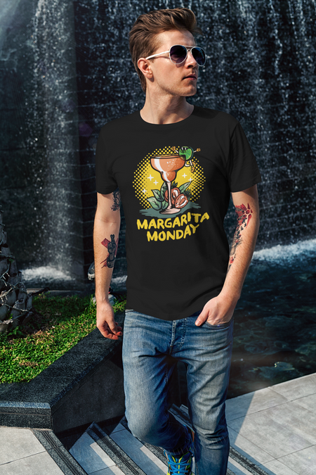Man wearing a black T-shirt with a "Margarita Monday" design, featuring a colorful margarita glass illustration and bold yellow text. This stylish Margarita Monday T-shirt design adds a playful, festive vibe to his casual outfit. The waterfall backdrop enhances the relaxed, adventurous look.