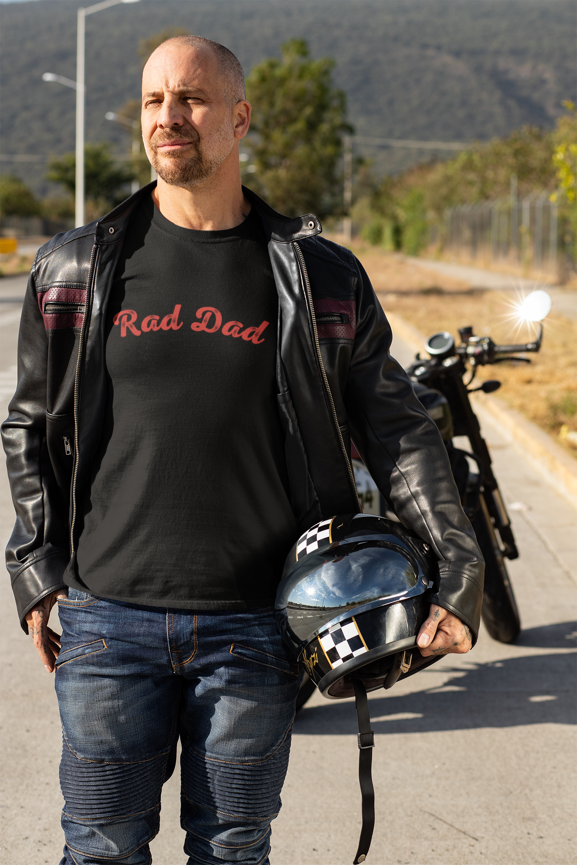 A Man standing ooutside wearing a t shirt with a Red Rad Dad Graphic on the front