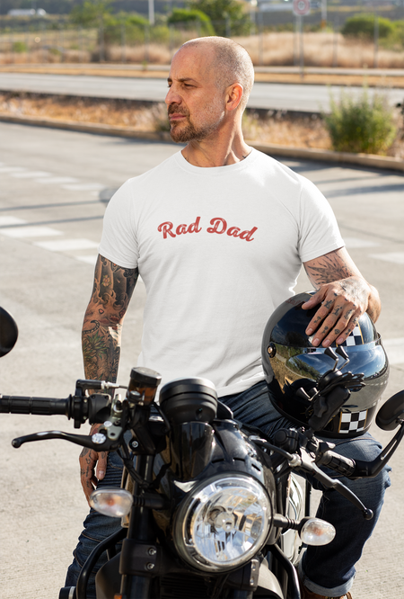 A Man standing ooutside wearing a t shirt with a Red Rad Dad Graphic on the front