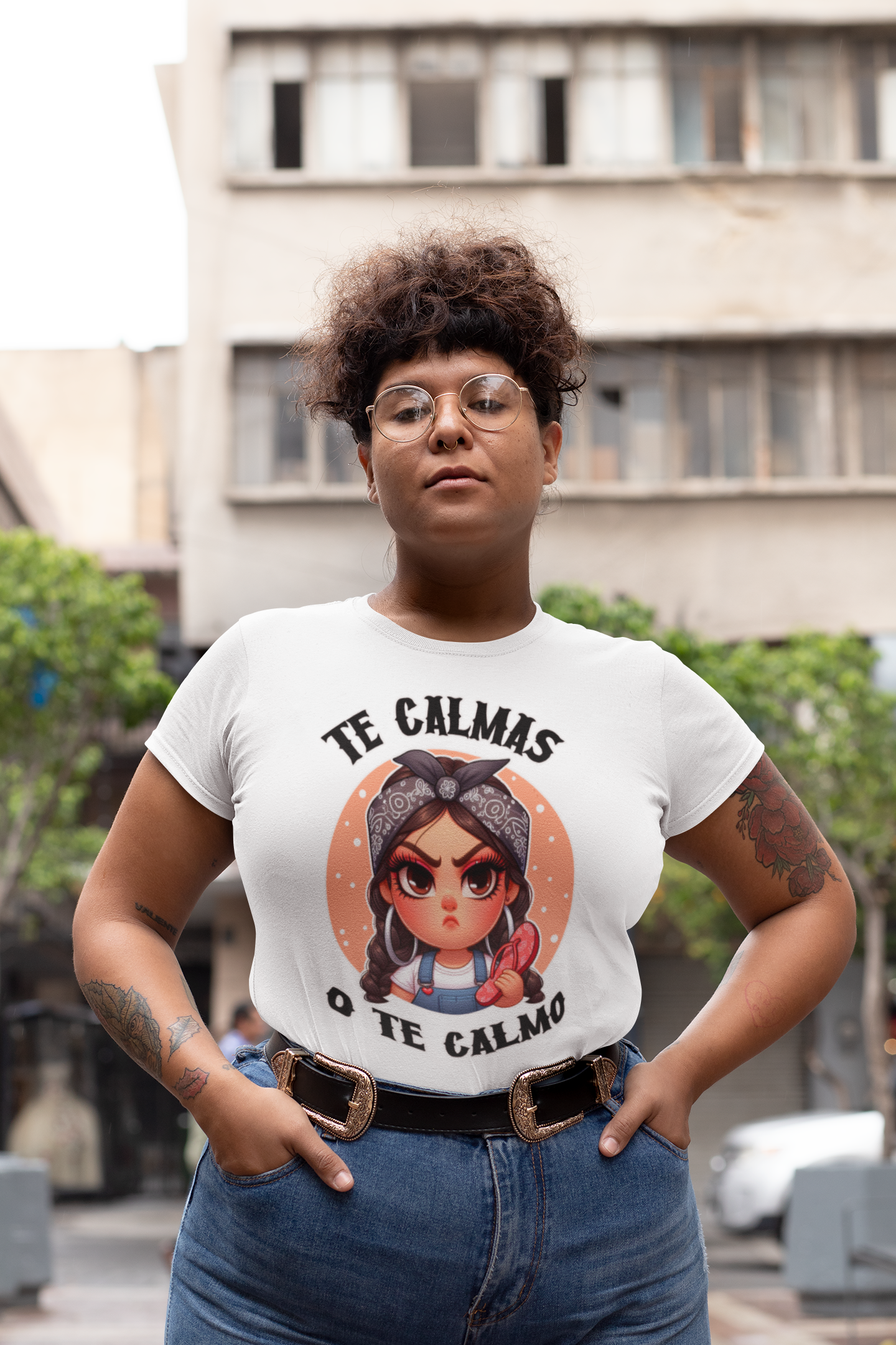 White T-shirt featuring a feisty cartoon character with the Spanish phrase 'Te Calmas o Te Calmo,' adding a humorous and bold statement. Ideal for those with a playful attitude and love for expressive, culturally inspired designs