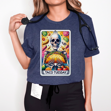 T-shirt with a unique 'Taco Tuesday' design featuring a skeleton holding a large taco, surrounded by vibrant ingredients like lime slices, chili peppers, and tomatoes. Perfect for those who enjoy a fun, slightly edgy take on Taco Tuesday.