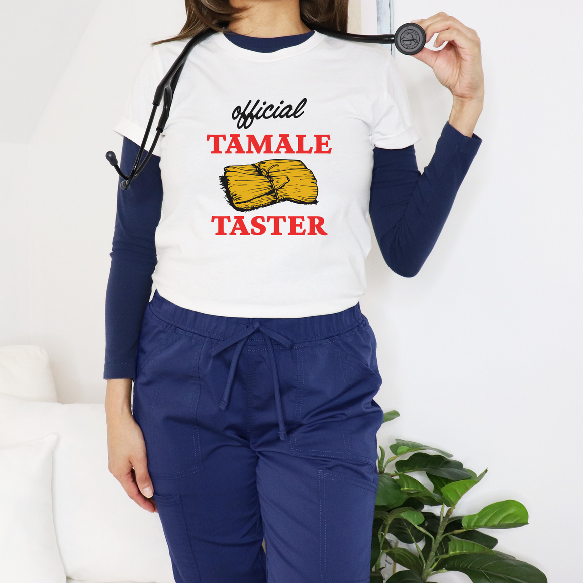 Smiling woman wearing a white T-shirt with bold red text 'Official Tamale Taster' and a tamale graphic, perfect for funny Christmas shirts and holiday gatherings.