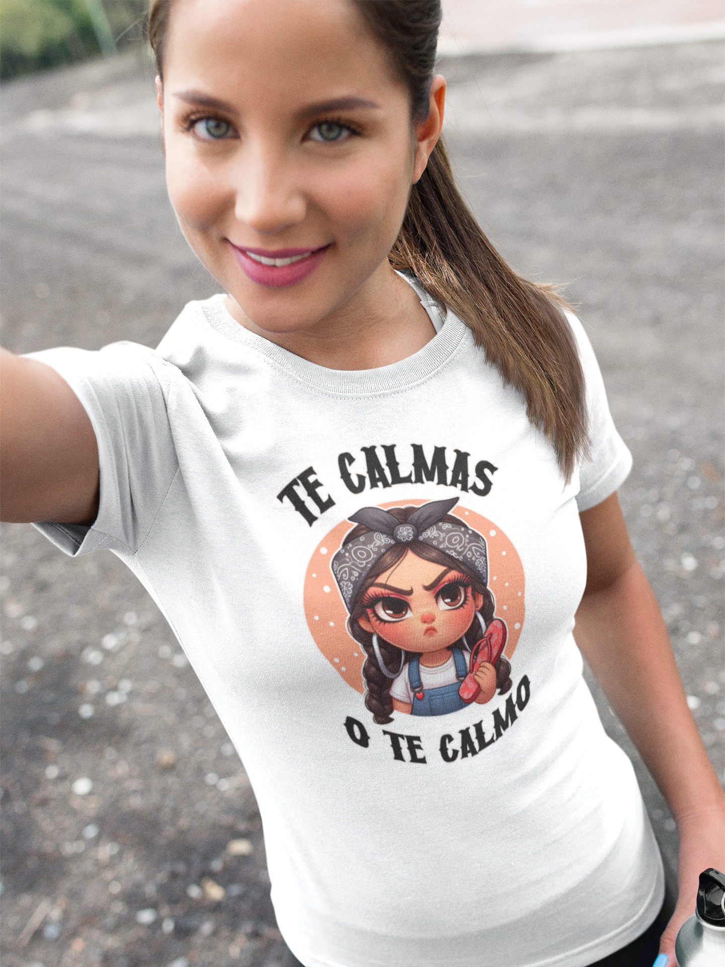 White T-shirt featuring a feisty cartoon character with the Spanish phrase 'Te Calmas o Te Calmo,' adding a humorous and bold statement. Ideal for those with a playful attitude and love for expressive, culturally inspired designs