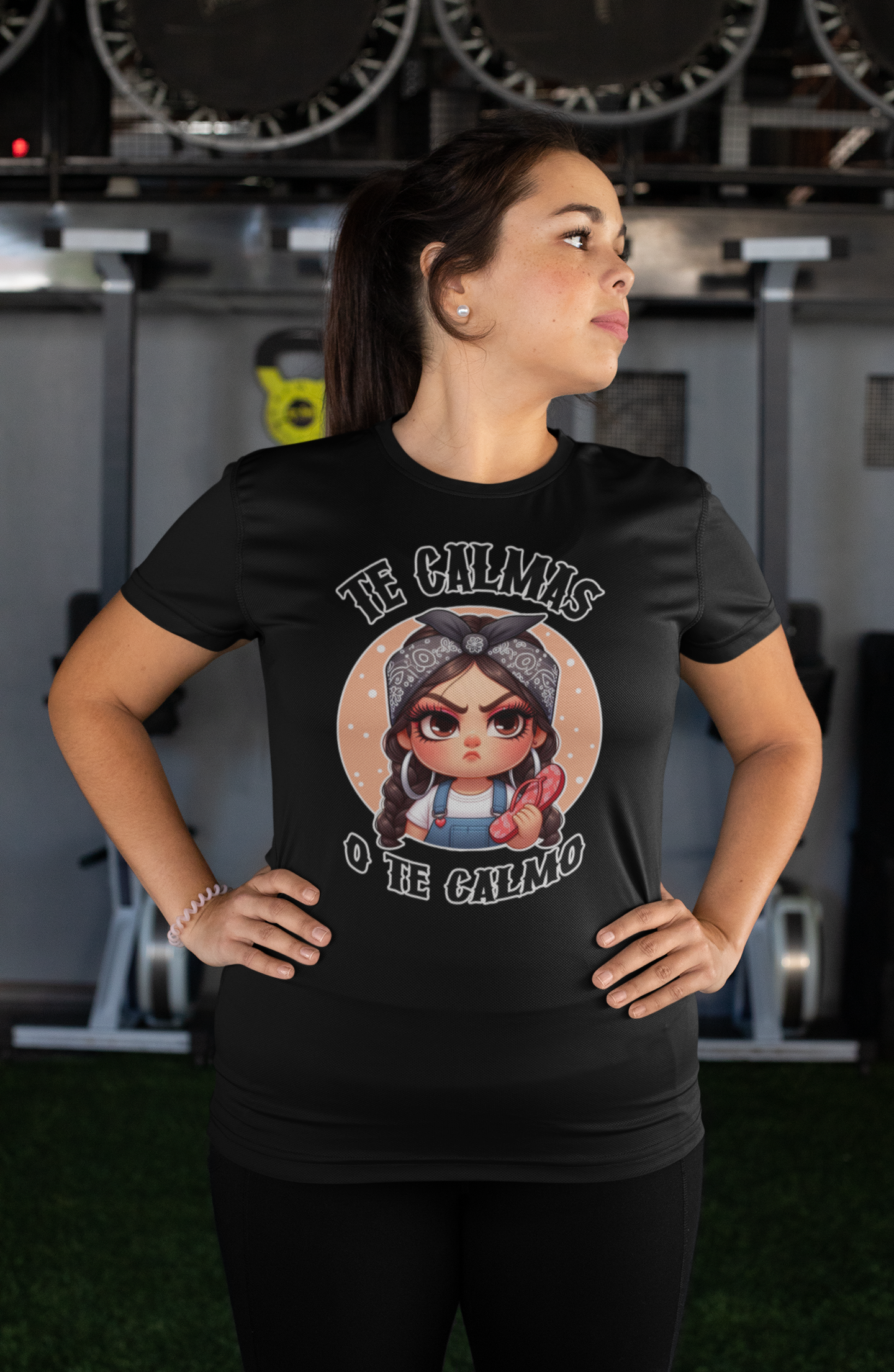 Black t-shirt featuring a feisty cartoon character with the Spanish phrase 'Te Calmas o Te Calmo,' adding a humorous and bold statement. Ideal for those with a playful attitude and love for expressive, culturally inspired designs