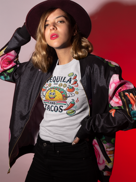 White T-shirt featuring a festive 'Tequila and Tacos' design with a smiling taco character, tequila bottle, margarita glass, lime slices, and chili peppers. Perfect for celebrating fiestas and taco nights with a fun and lively style.