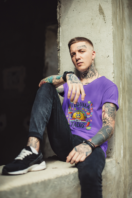 Purple T-shirt featuring a festive 'Tequila and Tacos' design with a smiling taco character, tequila bottle, margarita glass, lime slices, and chili peppers. Perfect for celebrating fiestas and taco nights with a fun and lively style.