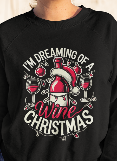 Black Christmas sweatshirt with a festive wine theme, featuring a Santa-capped wine bottle, wine glasses, ornaments, and the humorous text 'I'm Dreaming of a Wine Christmas.' Ideal holiday apparel for wine enthusiasts seeking a fun and stylish Christmas-themed sweatshirt.