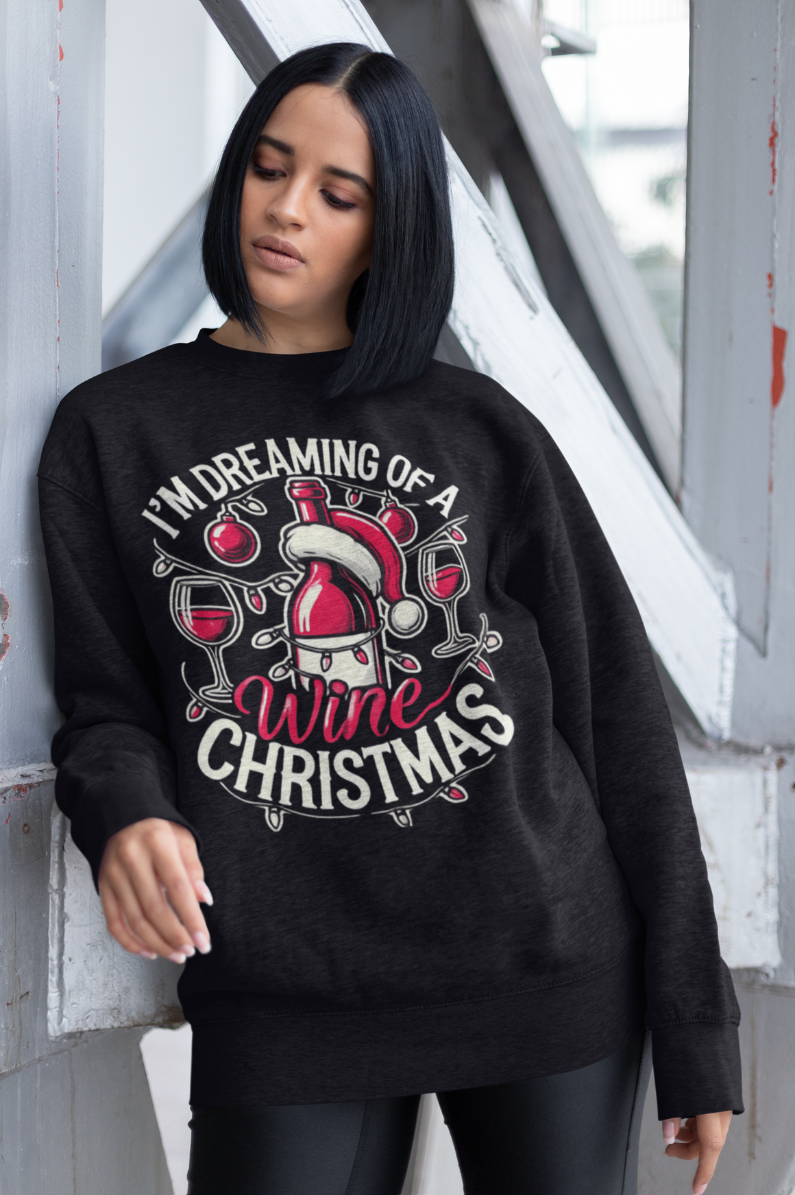 Black Christmas sweatshirt with a festive wine theme, featuring a Santa-capped wine bottle, wine glasses, ornaments, and the humorous text 'I'm Dreaming of a Wine Christmas.' Ideal holiday apparel for wine enthusiasts seeking a fun and stylish Christmas-themed sweatshirt.