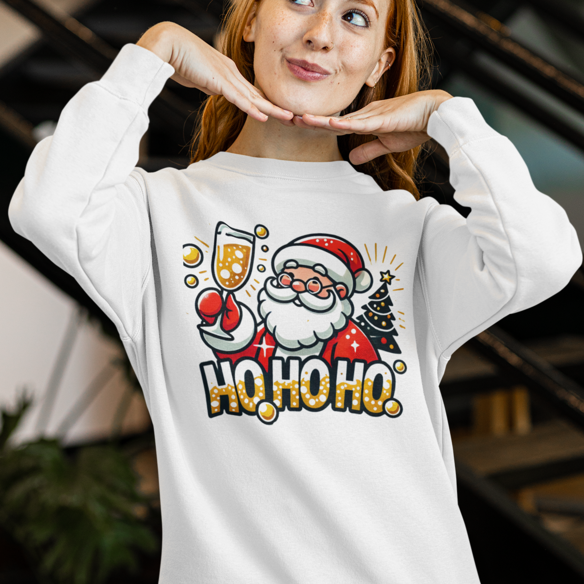 White Christmas sweatshirt featuring a cheerful Santa holding a champagne glass, next to a decorated Christmas tree and the festive text 'Ho Ho Ho.' A fun holiday sweatshirt perfect for adding Christmas cheer to any celebration.