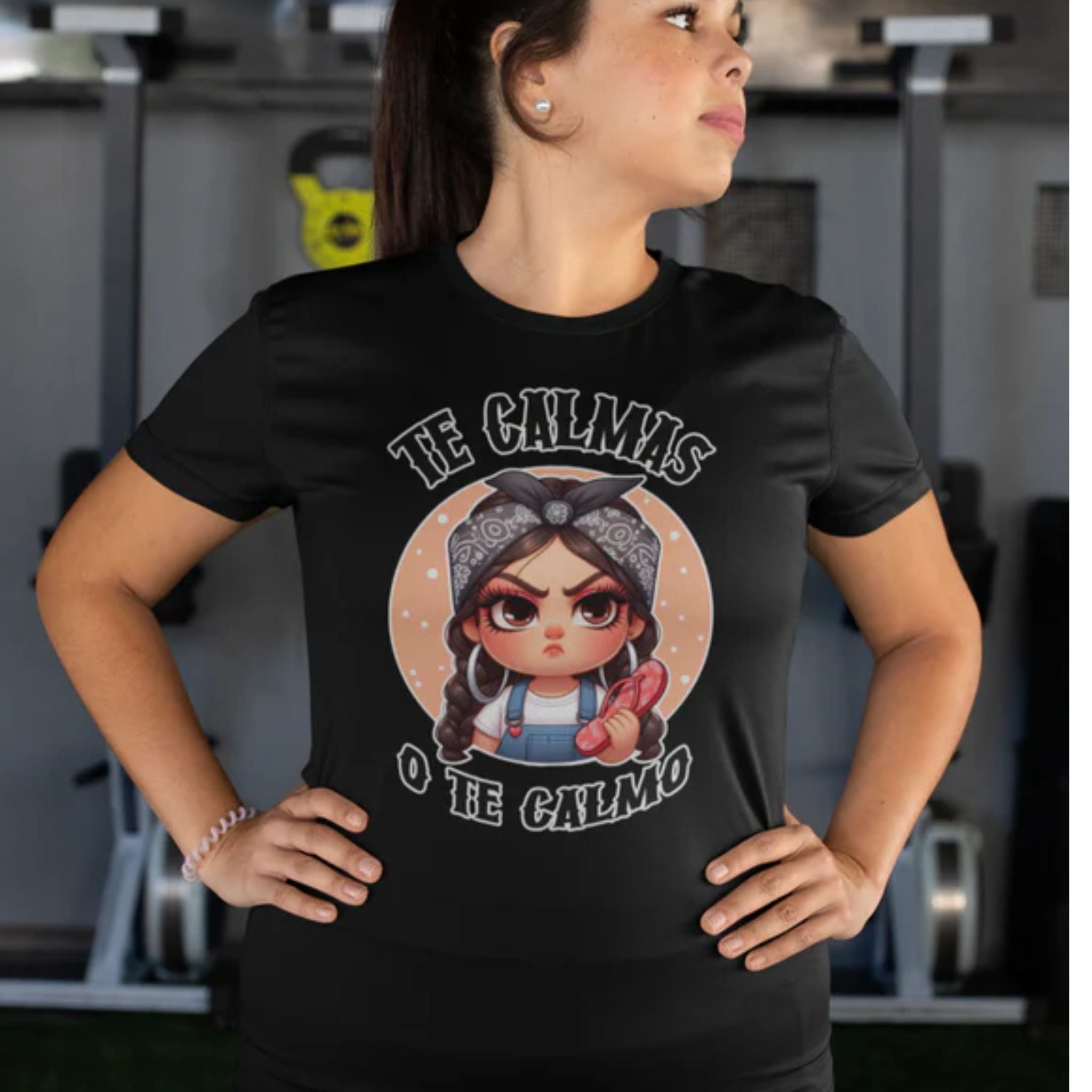 Black t-shirt featuring a feisty cartoon character with the Spanish phrase 'Te Calmas o Te Calmo,' adding a humorous and bold statement. Ideal for those with a playful attitude and love for expressive, culturally inspired designs